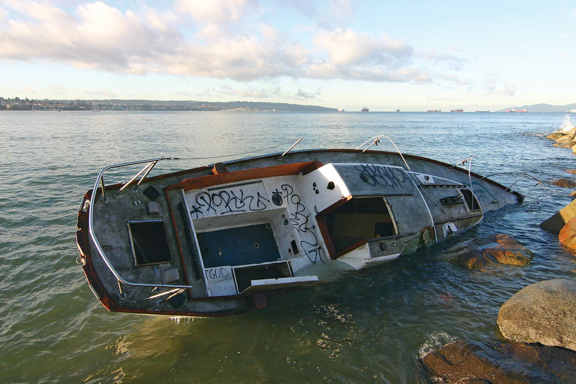 According to the City of Vancouver, "when an owner is not known or does not come forward, the City must pay the recovery and disposal costs.” This boat has been sitting on the rocks at Sunset Beach in Vancouver since November 19. Photo by Tyrone Stelzenmuller.